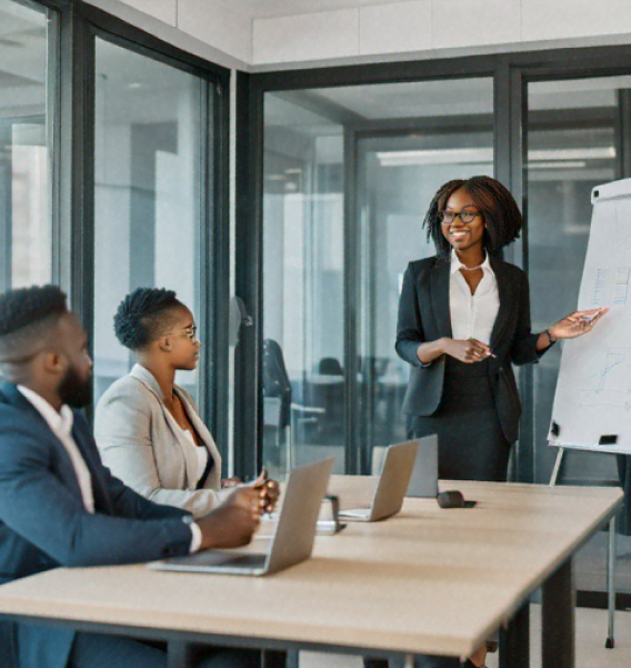 a lady leading a meeting in front of a whiteboard