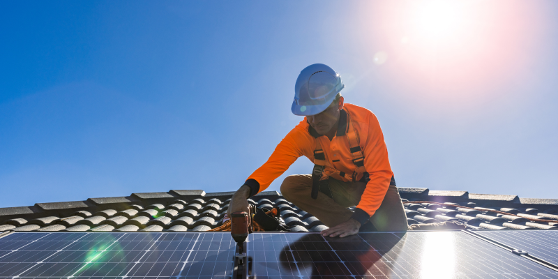 Man installing solar PV on roof